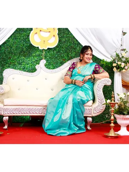 A beautiful mother-to-be at her baby shower. She is seated on an elegant white sofa against the green wall backdrop I set up for her special day.