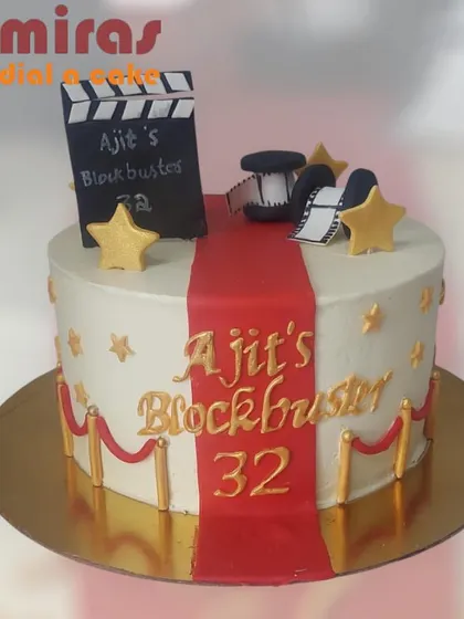 A blockbuster birthday cake for a movie lover. This design features a red carpet, a movie clapperboard, and film reels, making the birthday person the star of the show.