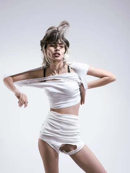 A raw, emotional pose. The torn clothing and the model's expression tell a story of rebellion and freedom.