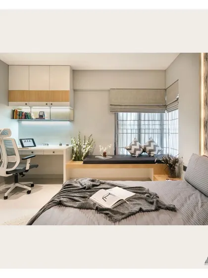This bedroom combines rest and productivity with a built-in study desk and a comfortable bay window seat. The neutral color palette creates a calm and focused environment.