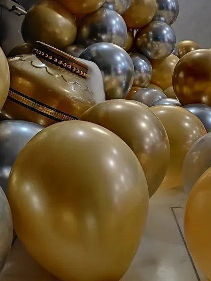 A close-up of the gold balloons and a traditional Indian instrument, showing how we incorporate personal elements into the decor.