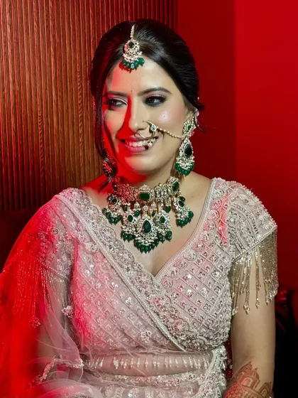 A candid, happy moment captured under dramatic lighting. Her makeup remains flawless and radiant.