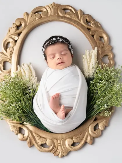 Framed like a precious work of art. Using a vintage-style golden frame and some greenery, we can create a truly unique and elegant portrait of your newborn.