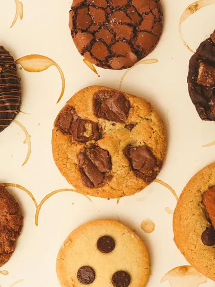 The perfect pairing: a rich, aromatic cup of coffee with our freshly baked cookies. This overhead shot shows a variety of our cookie flavors.