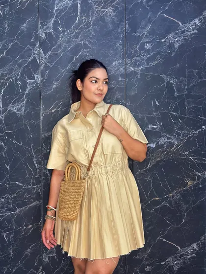 Showing how the mini straw bag can be worn as a crossbody for a more casual feel.