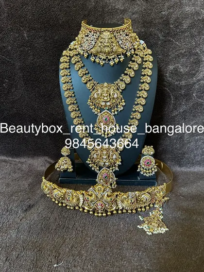 A majestic temple jewellery set featuring two large Lakshmi pendants on the choker and haaram. This rental includes a matching vaddanam.