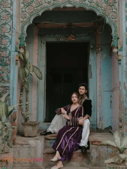 A relaxed and romantic portrait of the couple sitting on the steps of a historic building. This image captures a quiet moment of togetherness amidst a unique and cultural setting.