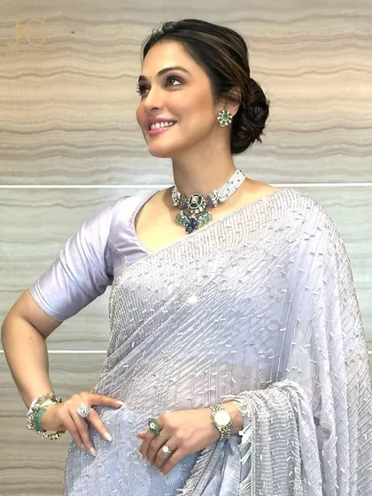 A joyful smile complemented by the rich green of our emerald and sapphire necklace. It's a piece that blends traditional craftsmanship with a touch of modern colour.