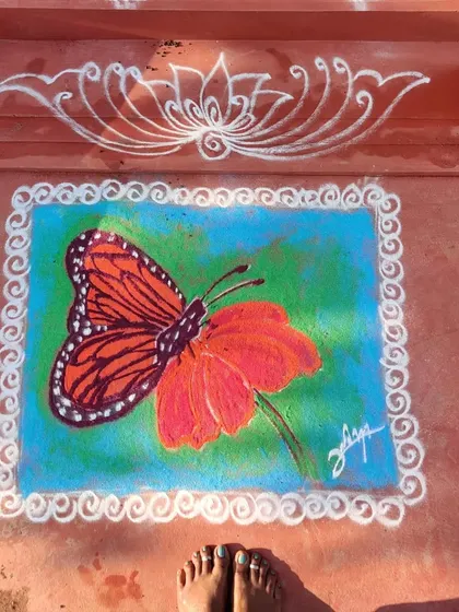A colorful rangoli I made of a butterfly on a flower, framed with a traditional white kolam border.