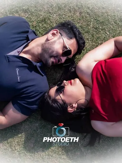 An intimate overhead shot of the couple lying on the grass. This perspective creates a romantic and personal portrait, focusing on their closeness.
