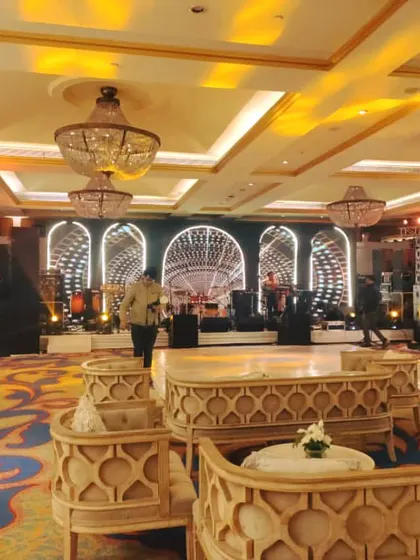 A wide view of a ballroom showing the stage setup with a live band and an intricate LED screen design. The lounge seating in the foreground is arranged to provide excellent views of the stage.