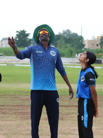 A coach demonstrates a high catch, providing a live example for his students to follow.