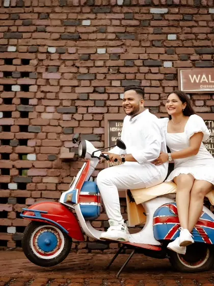 A fun and stylish shot with a vintage scooter against a cool brick wall. This is perfect for couples who want a chic, retro vibe for their pre-wedding photos.