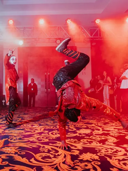 Mesmerizing the audience with their artistry, these performers in red create a stunning backdrop for the couple's grand entrance at their after-party.