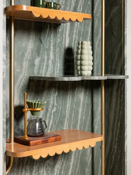 A detail of the custom shelving at 11 Grams Cafe. We mixed scalloped-edge wood shelves with green marble, all held within a delicate brass frame, creating a beautiful display for coffee-making tools and decor.