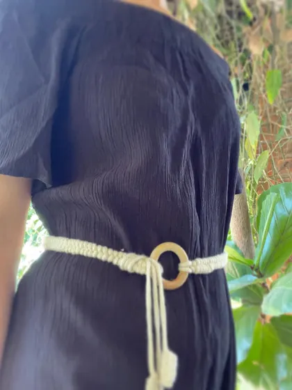 A close-up of the macrame belt with a wooden ring, styled on a black dress. It cinches the waist beautifully, adding shape and a touch of natural, bohemian texture.