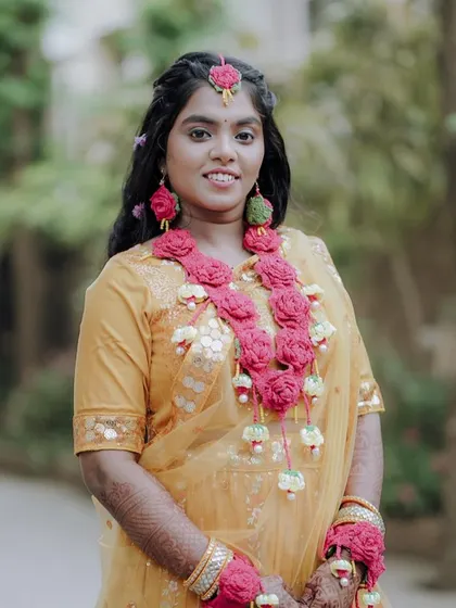 A smiling portrait of the bride in her yellow Haldi dress.