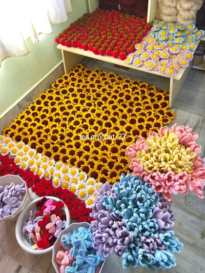 An overhead view of a massive 700-piece keychain order. This assortment includes colorful bow keychains, sunflowers, daisies, and strawberries, ready for a reseller.
