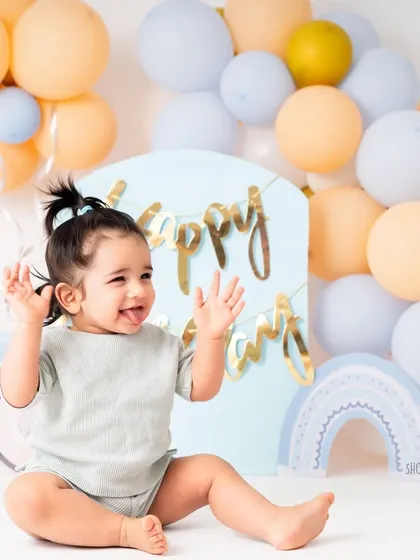 Waving hello to year one! This shot captures his playful spirit and the beautiful, soft-hued setup we created for his birthday photoshoot.