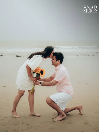 A sweet and tender moment as the groom-to-be kisses his fiancée's forehead during their pre-wedding photoshoot on the beach.