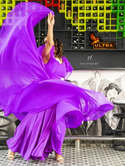 The purple gown captured mid-twirl, highlighting the sheer volume and movement of the design.
