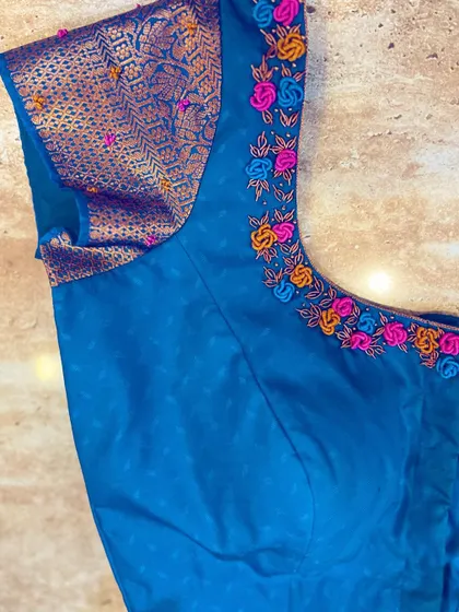 A side view of the French knot blouse, showing how the brocade sleeve contrasts beautifully with the plain body and colorful embroidery.