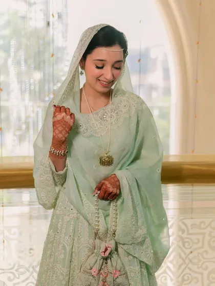 An angelic look for her Nikah ceremony. The bride's mint green outfit is paired with very minimal, clean makeup, highlighting her delicate features and serene expression.