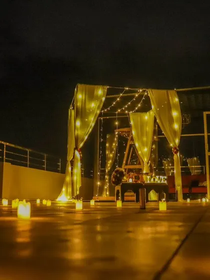 Our crazy cabana setup is perfect for a romantic dinner or a surprise proposal. This low-angle shot highlights the path of glowing candles leading to the beautifully lit cabana on a city rooftop at night.