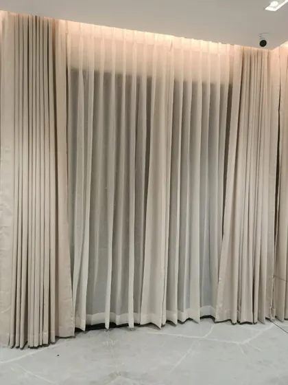 A beautiful installation of layered curtains, with a sheer inner panel and opaque outer panels, providing versatile options for light control and privacy.