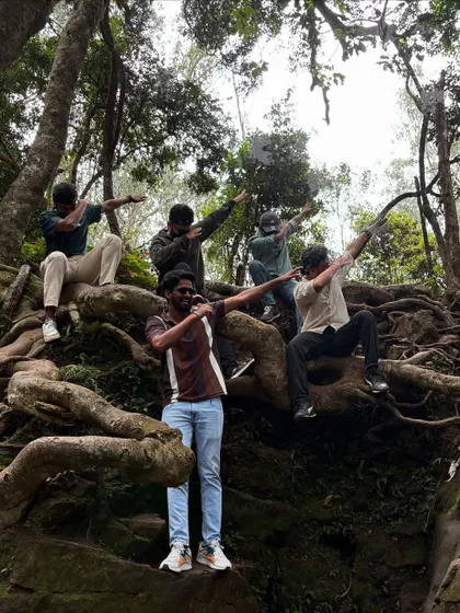 A group of guys striking a pose on the giant roots of a tree in Kodaikanal.