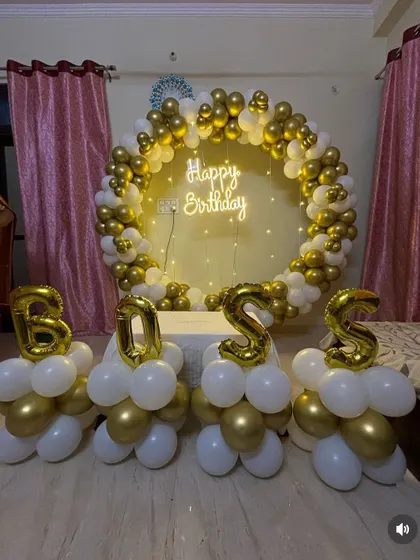 A closer look at the "BOSS" balloon letters in front of the elegant gold and white circular backdrop.