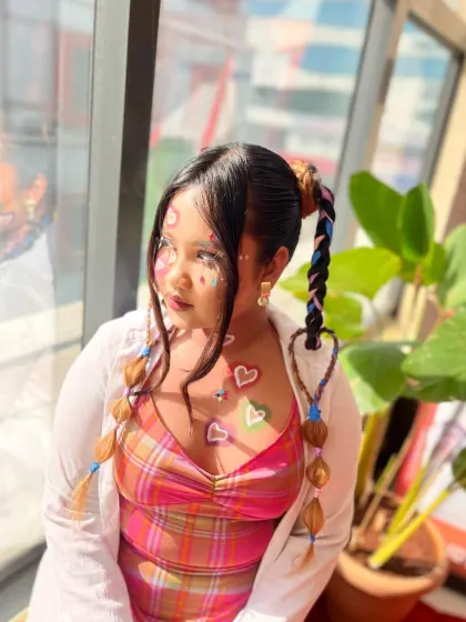 A playful and colorful makeup look with heart-shaped stickers and creative braids, showing the fun and imaginative side of makeup artistry.