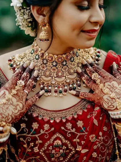 A detailed shot of the bride's stunning jewelry and intricate mehendi. This photo highlights the artistry and tradition that are integral parts of an Indian bridal look.