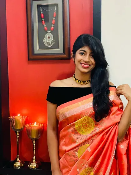 My daughter wearing an orange Kanjeevaram that I revamped with block prints. Paired with a modern off-shoulder blouse, it's a game-changer.