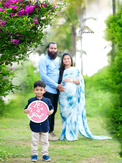In this variation of a gender reveal, the son holds a pink "It's a girl" sign. We offer different props and setups to ensure each family's announcement photo feels unique to them.