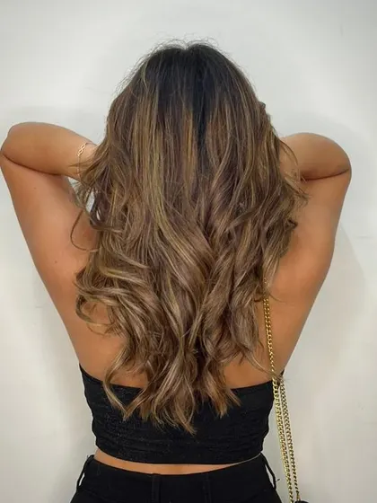 A little blonde moment. This client's hair is beautifully styled to showcase the soft blonde balayage that brightens her overall look.