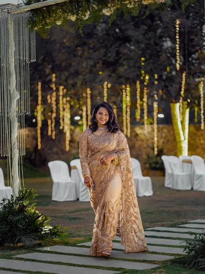 A beautiful outdoor shot of Ashwitha at her Bangalore reception. Her soft glam makeup and elegant saree made her look effortlessly chic against the beautifully lit backdrop.