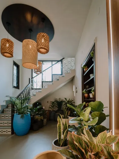 We believe greenery can elevate any interior. This beautiful entryway features a collection of our plants and planters, creating a warm and welcoming atmosphere that complements the home's luxury design and natural lighting.
