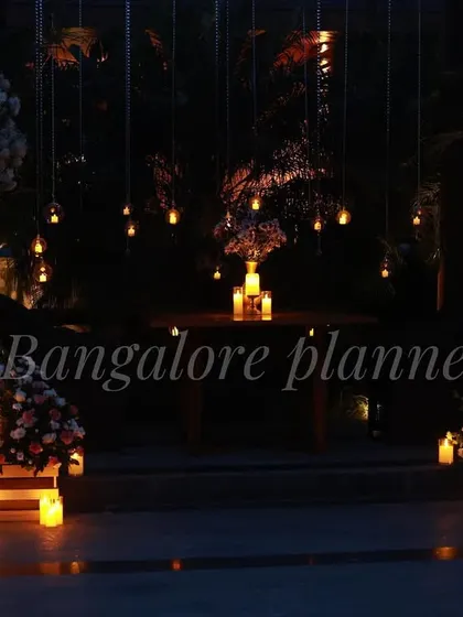 I specialize in creating magical, once-in-a-lifetime moments. This romantic outdoor dinner setup features hanging lights and candles for an unforgettable evening under the stars.