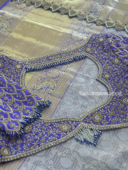 A purple blouse with intricate peacock feather embroidery.