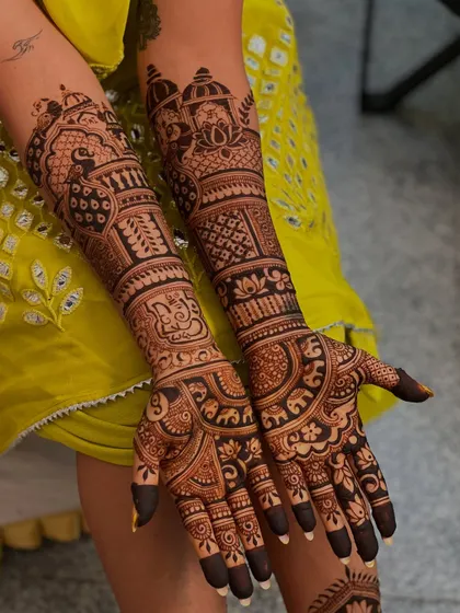 This design is packed with traditional motifs, including domes, peacocks, and intricate bands, covering the arms from the palms to the elbows for a truly royal look.