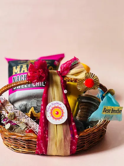 A wicker basket hamper for Rakhi, beautifully decorated with a red and gold bandhani-style wrap.