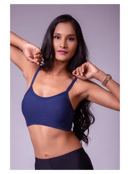 A strong and moody portrait in a sports bra. The lighting sculpts the model's features, creating a powerful and athletic look.