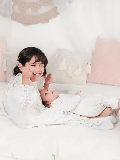 Pure joy and laughter between two sisters. This candid shot captures the playful side of their relationship in a beautiful, light-filled setting.