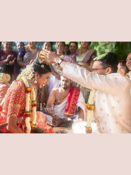 A candid shot of the wedding ceremony, filled with joy and tradition. The bride looks radiant and happy.