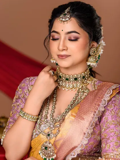 A moment of quiet reflection. This shot focuses on the bride's elegant profile, the detailed jewellery, and the soft texture of her silk saree.