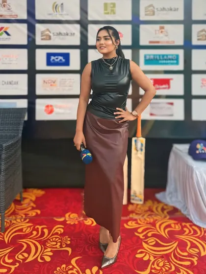 A full-length shot of my edgy black leather top and maroon skirt, perfect for a modern, stylish event like a sports league auction.