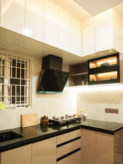 This view highlights the upper cabinets, showcasing the combination of solid and glass-fronted doors. The warm lighting creates a cozy ambiance while illuminating the contents of the display cabinets.