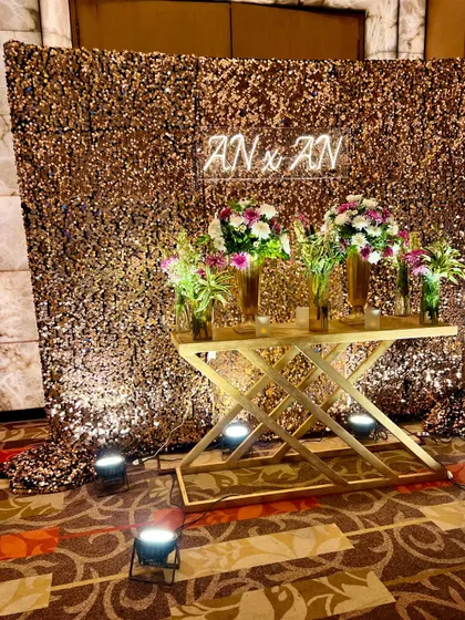 Even side backdrops matter. This glamorous photo corner features a gold sequin wall, a custom neon sign with the couple's initials, and a stylish console table.