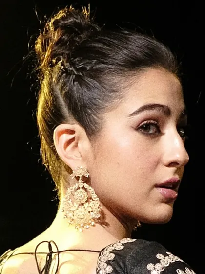 A close up of Sara Ali Khan, highlighting the intricate filigree work of the handcrafted Chandbali earrings. They are designed to be lightweight yet impactful.